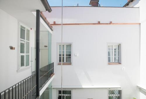 a white building with windows and a balcony at Boutique Hotel Dom - Rooms & Suites in Graz