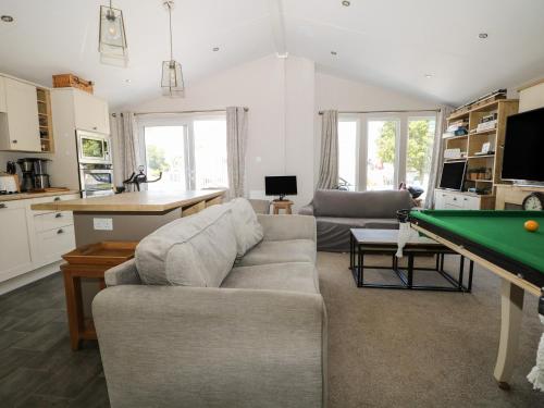 a living room with a couch and a pool table at The Goodwood Lodge in Chichester