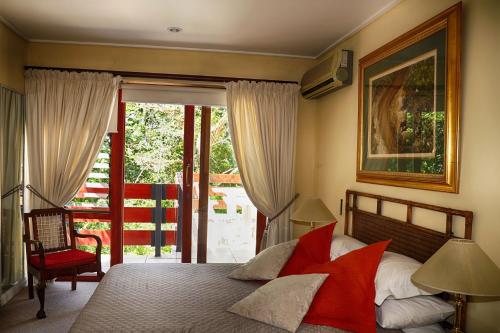 a bedroom with a bed and a sliding glass door at Auberge de Courtrai in Paarl