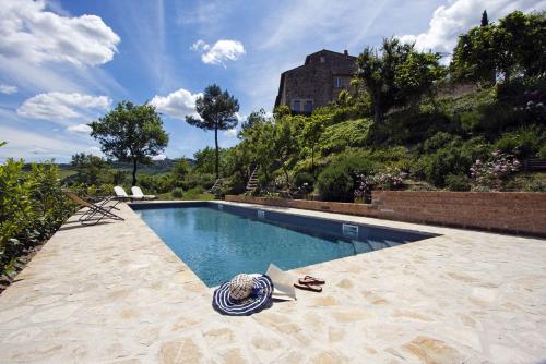 a swimming pool with a towel on the ground next to a house at Gli Appartamenti Di Torre Bertona in Todi