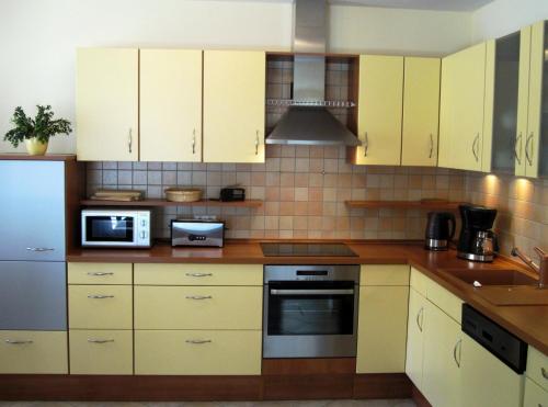 uma cozinha com armários amarelos e um micro-ondas em Haus Ostseeduo FeWo Nr. 4 em Bansin