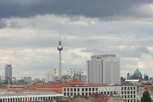 Blick auf eine Stadt mit einem Fernsehturm im Hintergrund in der Unterkunft Studio Apartment über den Wolken in Berlin