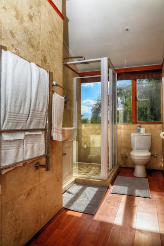 a bathroom with a toilet and a glass shower at Auberge de Courtrai in Paarl