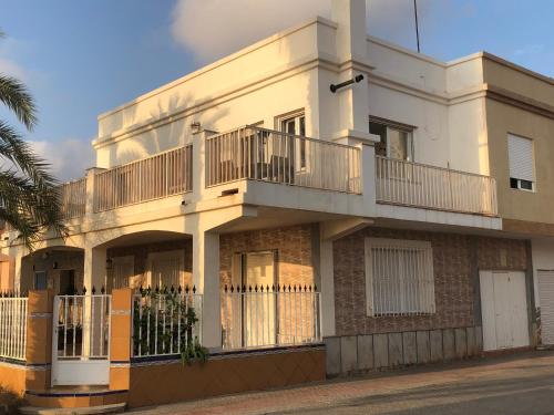 a white building with a balcony on top of it at Fantastic, Front line, Penthouse Apartment with amazing views in Los Urrutias