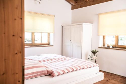 1 dormitorio con 1 cama y 2 ventanas en Berg-Loft Ramsau, en Ramsau