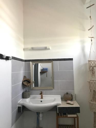 a white bathroom with a sink and a mirror at LES ALOÈS By CREYOL ANIMAL in Grand-Bourg