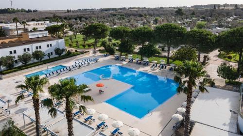 an overhead view of a large pool with palm trees at Dolmen Sport Resort in Minervino di Lecce