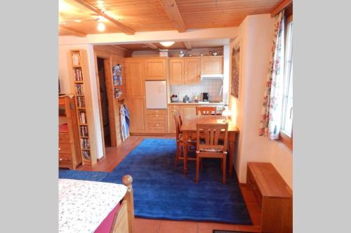 a kitchen and dining room with a table and a blue rug at Olle and Maria's B&B- apartment in Gimmelwald