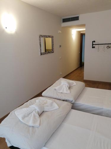 two beds in a room with towels on them at Ferrari Formula 1 in Orio al Serio