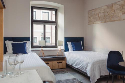 a bedroom with two beds and a table and chairs at Pod Jasną 28 in Częstochowa