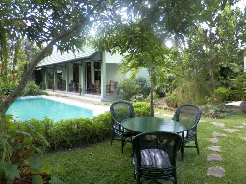 a table and chairs next to a swimming pool at Rumah Sawah in Yogyakarta