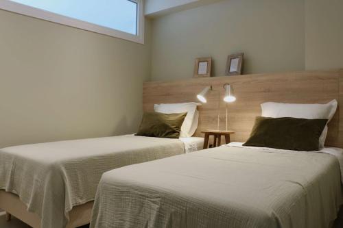 dwa łóżka w pokoju z oknem w obiekcie Jardines del Mar ,Casa Apolonia w Marbelli