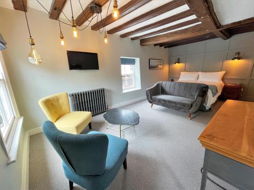 1 dormitorio con cama, sofá y sillas en The Marlborough Dedham en Dedham