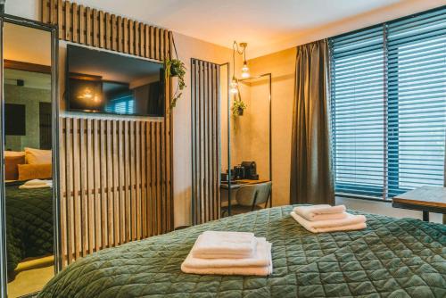 a hotel room with two towels on a bed at SoHotel in Schagen