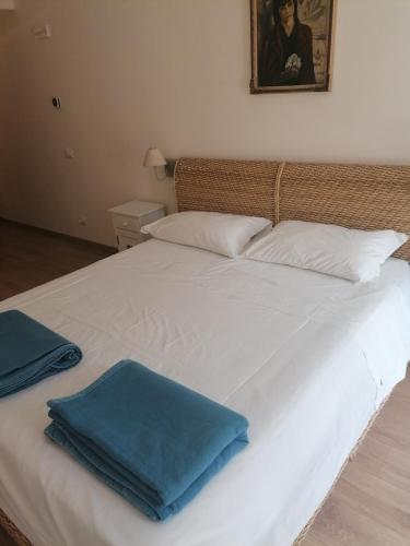 a white bed with two blue pillows on it at Ferrari Formula 1 in Orio al Serio