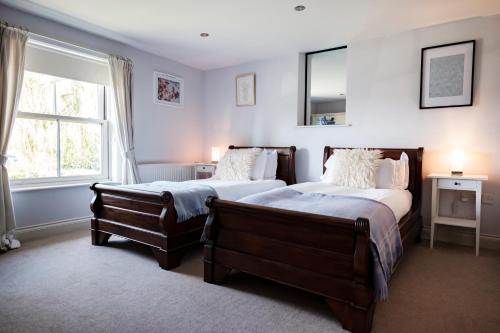a bedroom with two beds and a window at The Bower Inn in Bridgwater