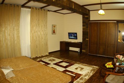 a living room with a bed and a tv at Platan in Samarkand