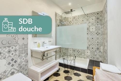 a white bathroom with a sink and a shower at Appartement Saint Jean in Lyon