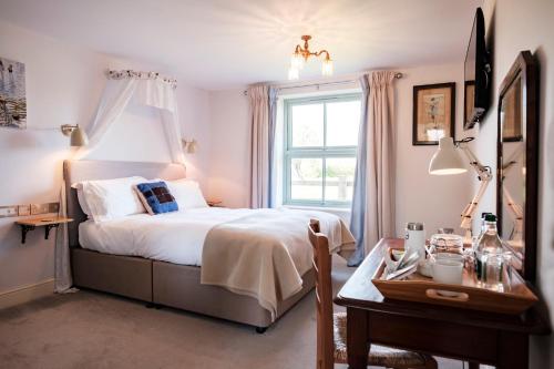 a bedroom with a bed and a window and a table at The Bower Inn in Bridgwater