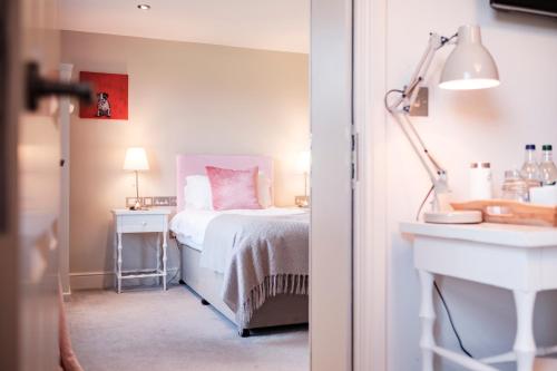 a bedroom with a bed and a desk with a lamp at The Bower Inn in Bridgwater