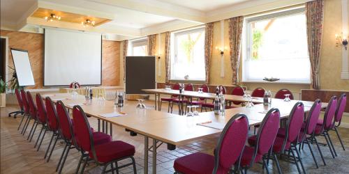 a conference room with tables and chairs and a screen at Der Dorfwirt in Rechberg