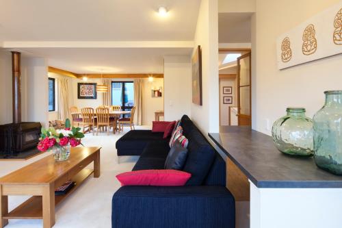 a living room with a couch and a table at Spinnaker Bay Apartments in Queenstown