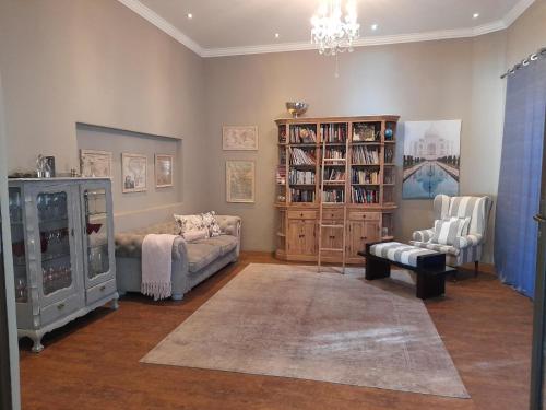 a living room with a couch and a book shelf at Safari Villa Boutique Hotel in Windhoek