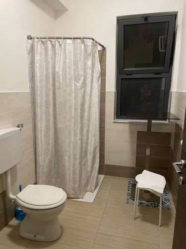 a bathroom with a toilet and a flat screen tv at B&B Cuciti in Milazzo