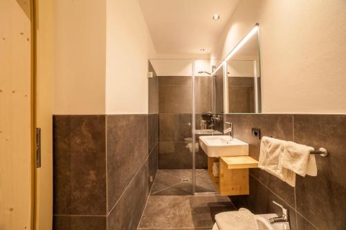 La salle de bains est pourvue d'un lavabo et d'un miroir. dans l'établissement Apartment Sofia Klein, à Lagundo