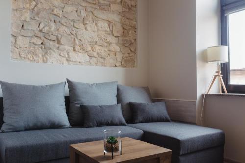 a living room with a blue couch and a stone wall at Pod Jasną 28 in Częstochowa