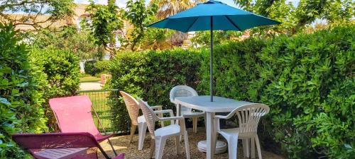 a table and chairs with an umbrella on a patio at SOLEIL34 in Palavas-les-Flots