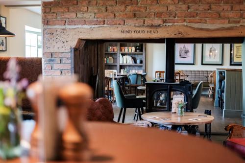 a living room with a fireplace and tables and chairs at The Bower Inn in Bridgwater