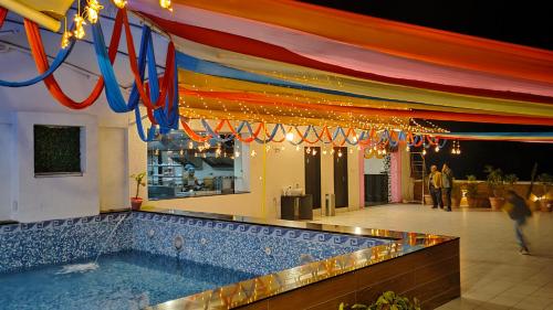 ein Schwimmbad mit farbenfrohem Baldachin darüber in der Unterkunft Hotel Grand Kaushalya in Sohāgpur