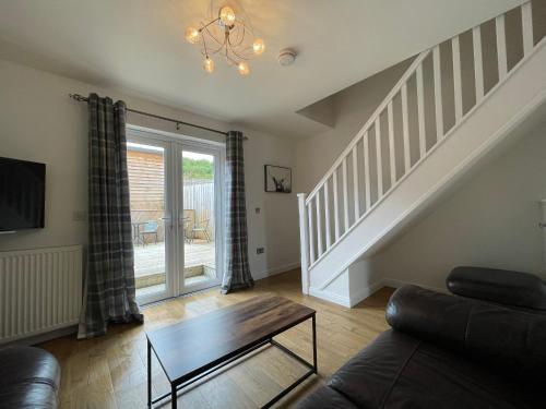 a living room with a couch and a table at Gorsebank Mews, Stylish Modern 2-Bed Townhouse with Private Garden in Inverness