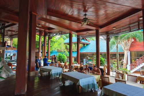 a restaurant with tables and people sitting at tables at Haad Yao Bayview Resort & Spa - SHA plus Certified in Haad Yao