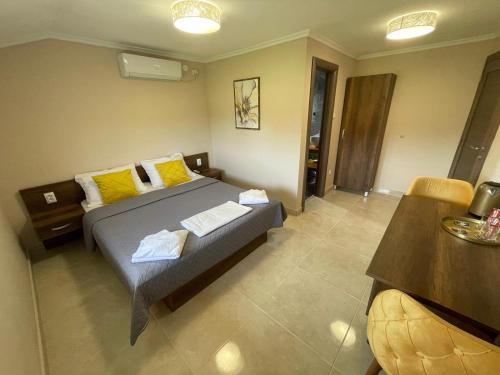 a bedroom with a bed with yellow pillows at Vila Boska Palic in Palić