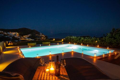 a swimming pool at night with candles and lights at Villa Castalia by Thalassa Residence Mykonos in Elia Beach