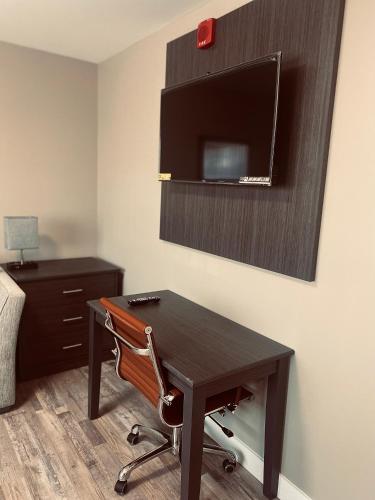 a room with a desk with a chair and a tv at Econo Lodge in Prince George
