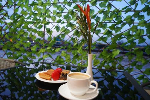 a table with a plate of food and a cup of coffee at HOTEL ASTRAL in Abidjan