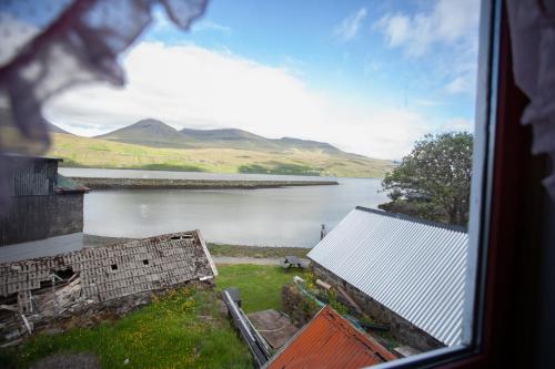 a view of a body of water from a window at Cozy house in the idyllic village of Haldórsvík in Haldarsvík