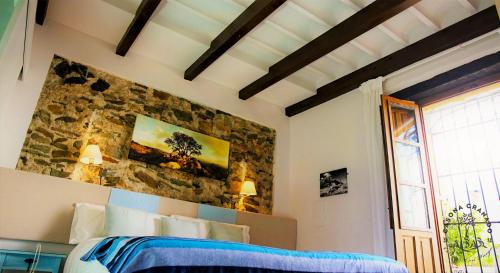 a bedroom with a bed and a stone wall at Casona Granado in El Pilar y Provincias