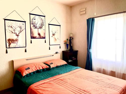 een slaapkamer met een bed en wat foto's aan de muur bij PENSION YunShuiYao雲水瑶民宿 in Furano
