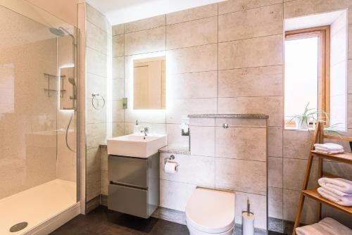 a bathroom with a shower toilet and a sink at Brecks Farm - Cow Kennels in York