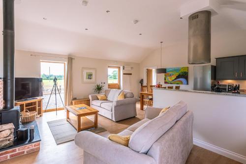 a living room with two couches and a fireplace at Brecks Farm - Cow Kennels in York