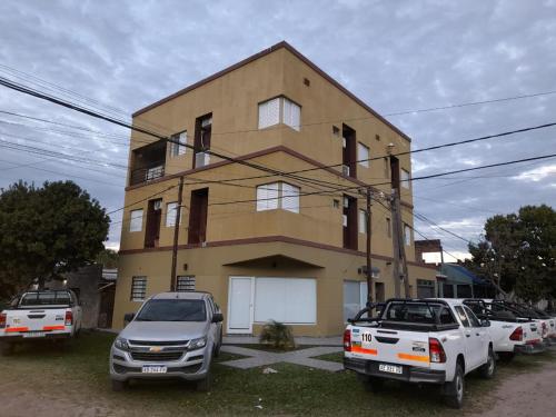 un edificio con coches estacionados frente a él en WINTER Departamentos Temporarios, en Formosa