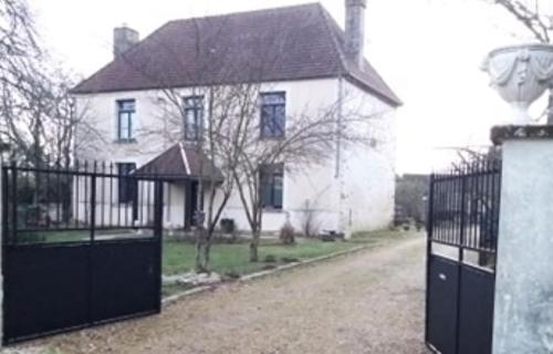 a white house with a gate in front of it at Hôtellerie Jardiniers Gourmands in Morsains