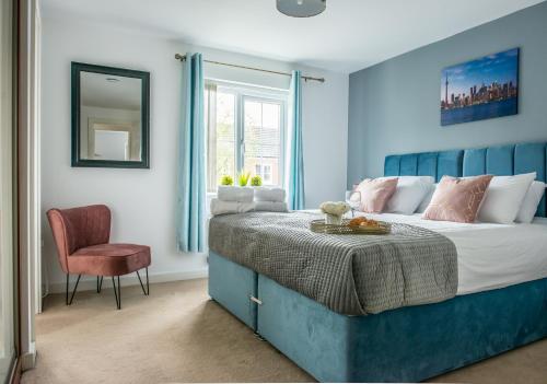 een blauwe slaapkamer met een bed en een stoel bij RATED 'EXCEPTIONAL' 3 BEDROOM HOUSE, SLEEPS 6, FREE PARKING, Near NEC in Tile Hill