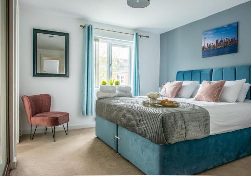 a blue bedroom with a bed and a chair at RATED 'EXCEPTIONAL' 3 BEDROOM HOUSE, SLEEPS 6, FREE PARKING, Near NEC in Tile Hill