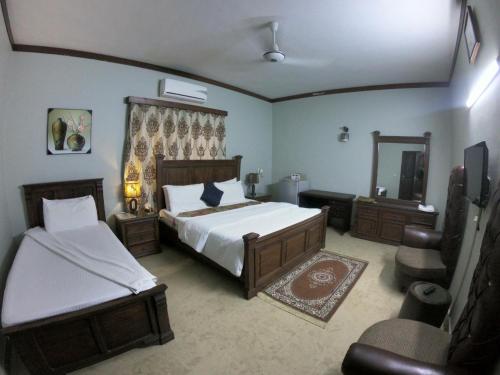 a bedroom with two beds and a mirror at Seaview Guest House in Karachi