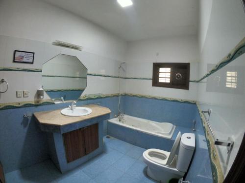a bathroom with a sink and a tub and a toilet at Seaview Guest House in Karachi
